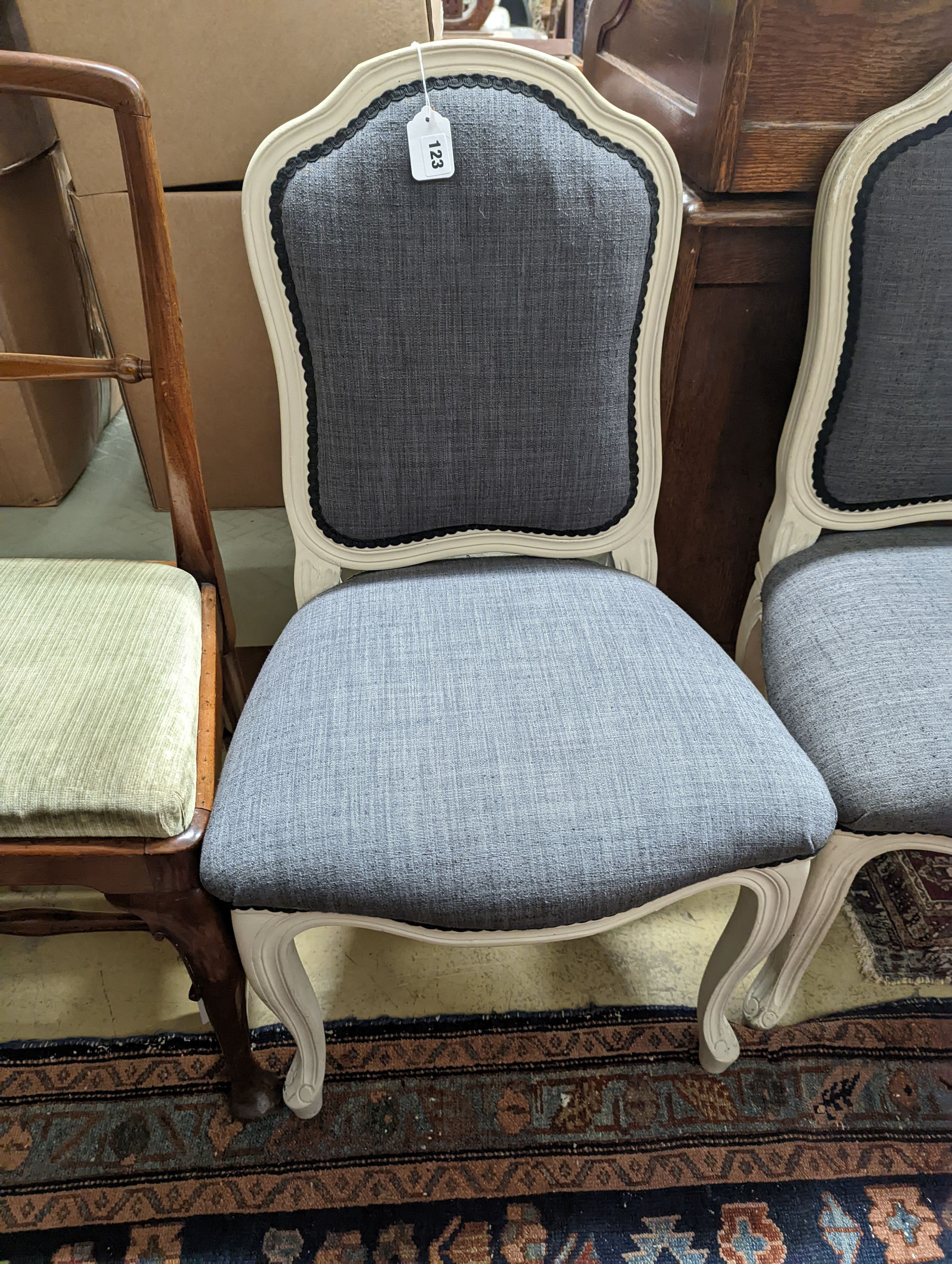 A pair of grey upholstered dining chairs